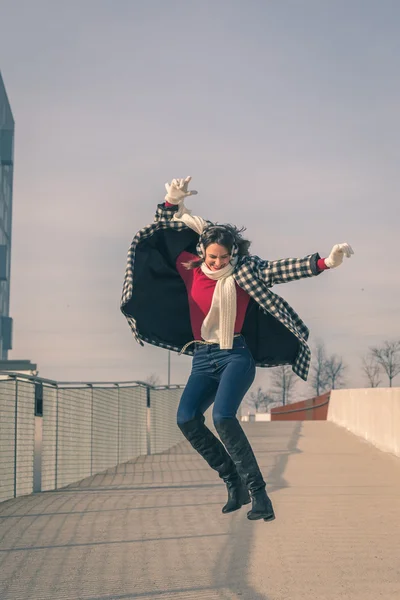 Красивая юная брюнетка прыгает по улицам города — стоковое фото