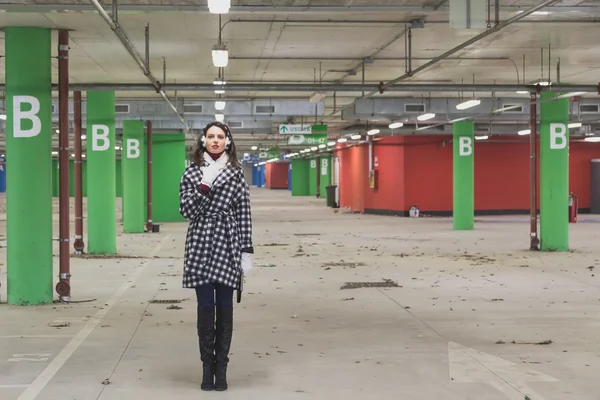 Beautiful young brunette posing in a parking garage — Stock Photo, Image