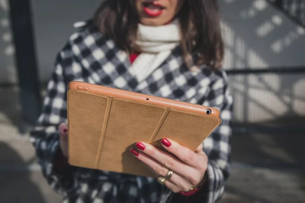 Dettaglio di una giovane donna che usa il suo tablet per le strade della città — Foto Stock