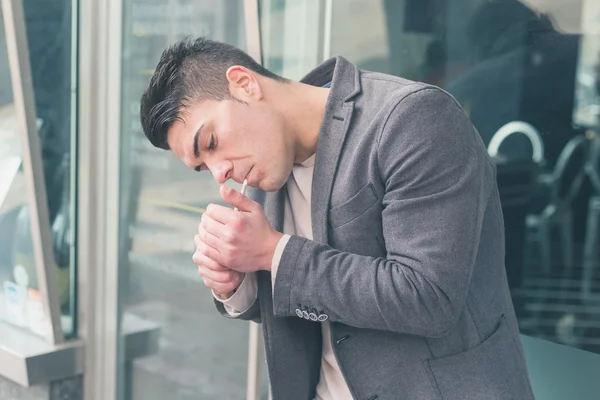 Joven hombre guapo fumando un cigarrillo — Foto de Stock