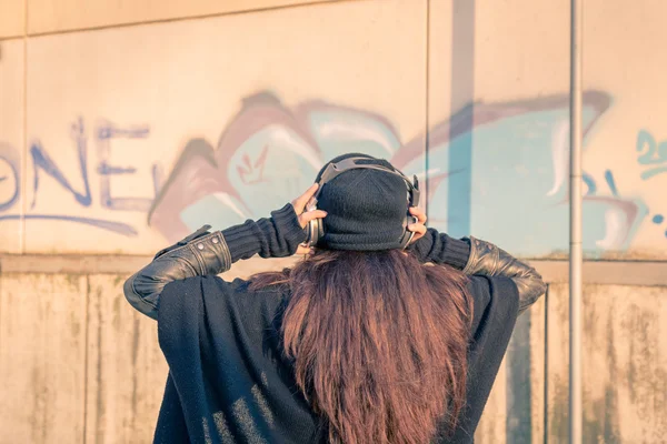 Vacker ung kvinna lyssna på musik på stadens gator — Stockfoto