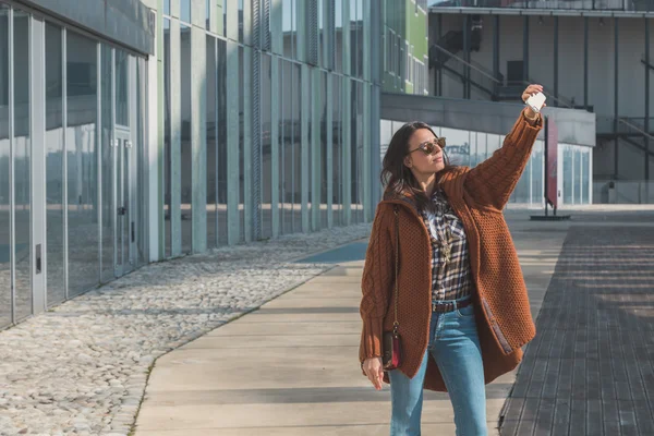 Vacker flicka med en selfie i en stadsmiljö — Stockfoto