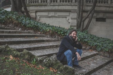 Genç yakışıklı sakallı adam şehir sokaklarını poz