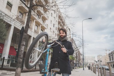 Genç yakışıklı sakallı adam onun bisiklet ile poz