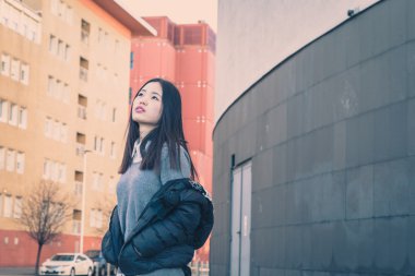 Genç güzel Çinli kız şehir sokaklarını poz