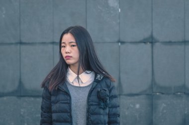 Genç güzel Çinli kız şehir sokaklarını poz