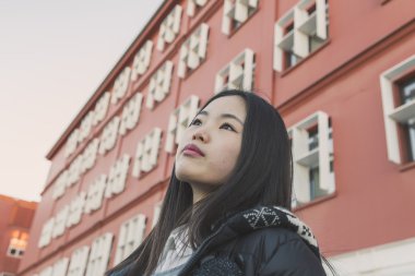 Genç güzel Çinli kız şehir sokaklarını poz