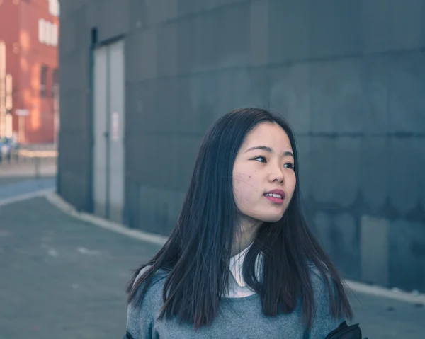 Young beautiful Chinese girl posing in the city streets — Stock Photo, Image