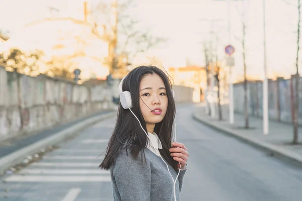 Young beautiful Chinese girl with headphones — Stock Photo, Image