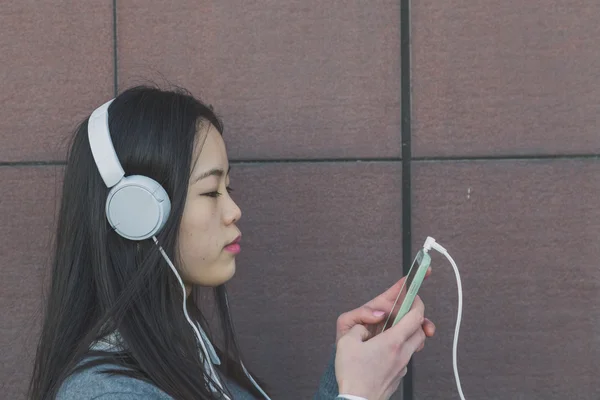 Mladá krásná čínská dívka se sluchátky — Stock fotografie