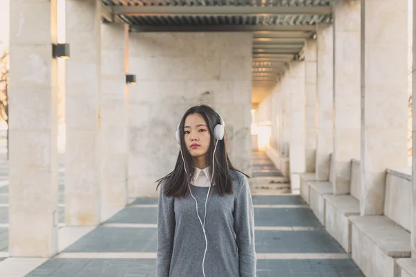 Young beautiful Chinese girl with headphones — Stock Photo, Image