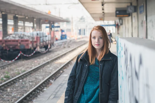 Beautiful girl posing in a railroad station — Stock Photo, Image