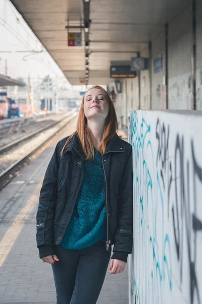 Beautiful girl posing in a railroad station — Stock Photo, Image