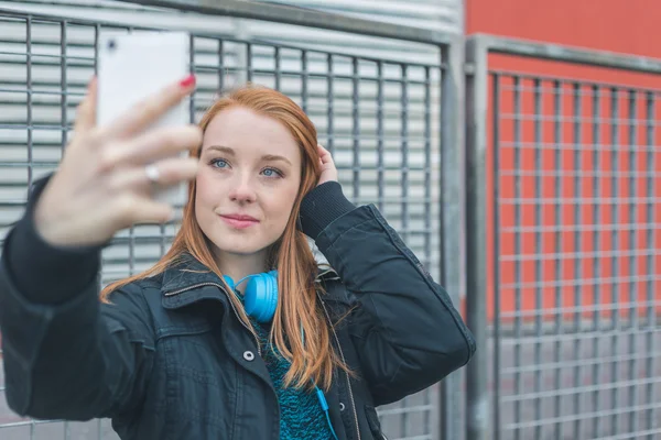 Vacker flicka med en selfie i stadens gator — Stockfoto