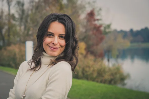 Beautiful young woman posing in a city park — Stock Photo, Image