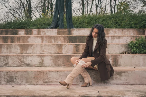 Belle jeune femme assise sur des marches en béton — Photo