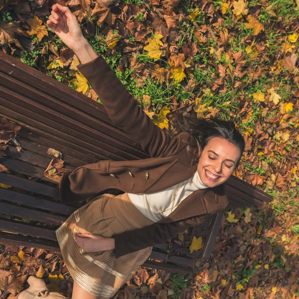 Beautiful young woman posing in a city park — Stock Photo, Image