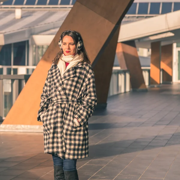 Krásná mladá brunetka pózuje v ulicích města — Stock fotografie