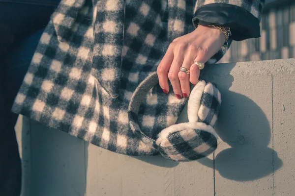 Dettaglio di una mano femminile con paraorecchie termiche — Foto Stock