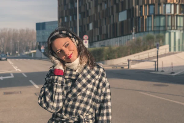 Krásná mladá brunetka pózuje v ulicích města — Stock fotografie