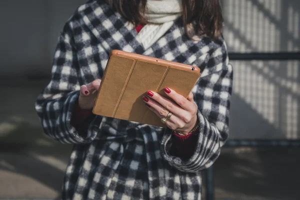 Деталь молодой женщины, использующей планшет на улицах города — стоковое фото