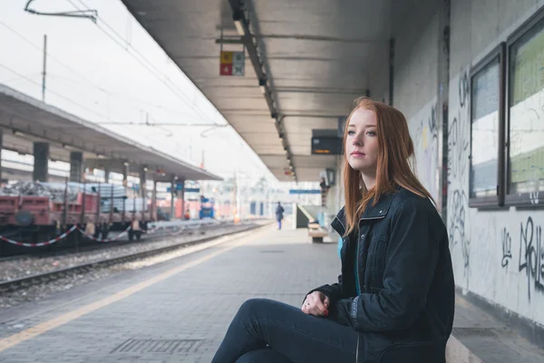 Beautiful girl posing in a railroad station — Stock Photo, Image