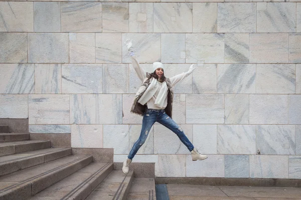 Beautiful young woman jumping down stairs — Stock Photo, Image