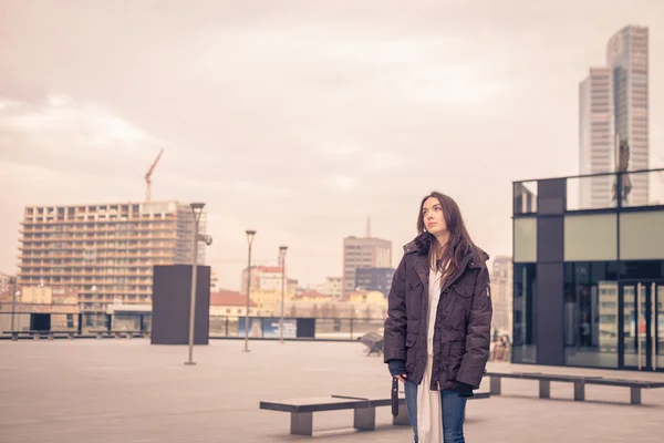 Krásná mladá dívka pózuje v ulicích města — Stock fotografie