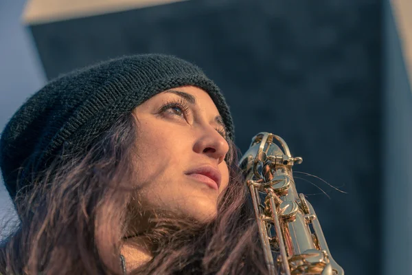 Beautiful young woman with her saxophone — Stock Photo, Image