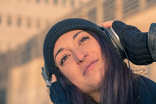 Belle jeune femme à l'écoute de la musique dans les rues de la ville — Photo