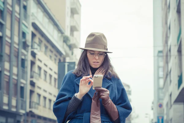 Hermosa joven morena mensajes de texto en las calles de la ciudad — Foto de Stock