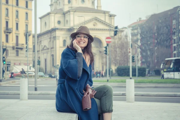 Krásná mladá brunetka na telefonu v ulicích města — Stock fotografie