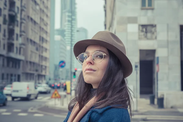 Krásná mladá brunetka pózuje v ulicích města — Stock fotografie