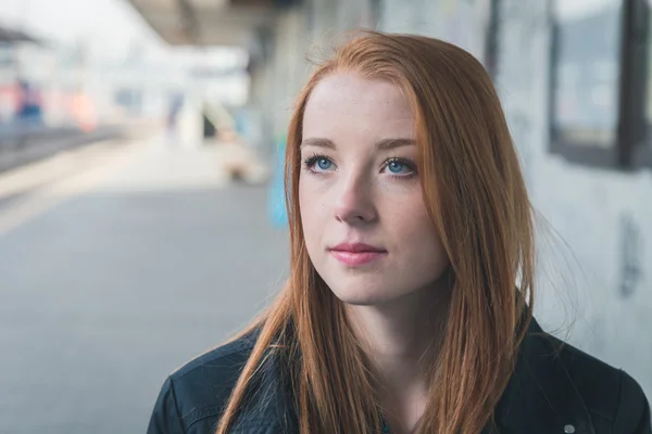 Beautiful girl posing in a railroad station — Stock Photo, Image