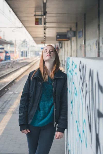 Güzel kız bir demiryolu istasyonunda poz — Stok fotoğraf