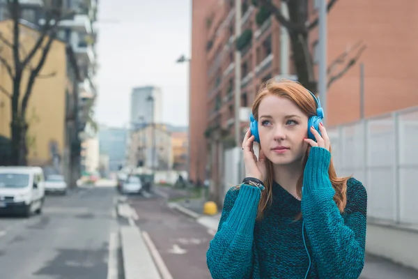 Красивая девушка слушает музыку на улицах города — стоковое фото