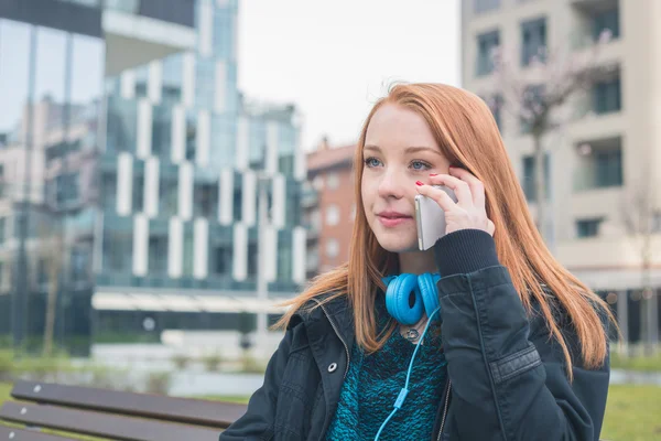 Красивая девушка разговаривает по телефону в городском контексте — стоковое фото