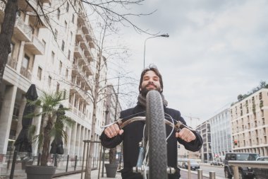 Genç yakışıklı sakallı adam onun bisiklet ile poz