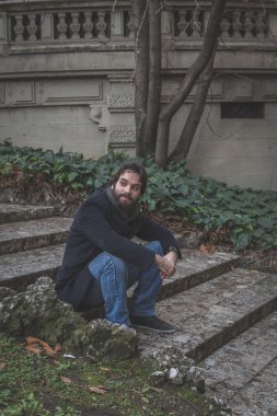 Genç yakışıklı sakallı adam şehir sokaklarını poz