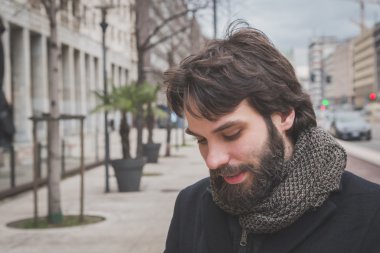 Genç yakışıklı sakallı adam şehir sokaklarını poz