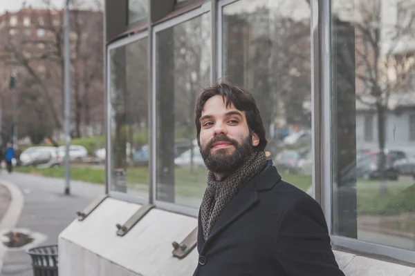 Young handsome bearded man posing in the city streets