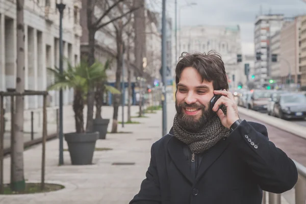 Young handsome bearded man talking on phone — Stock Photo, Image