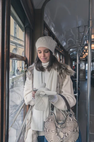 Beautiful young woman posing on a tram — Stock Photo, Image