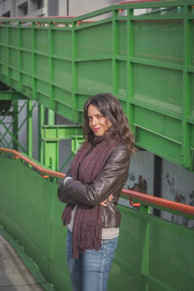 Beautiful young brunette posing on a bridge — Stock Photo, Image