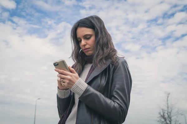 Hermosa joven morena mensajes de texto en las calles de la ciudad — Foto de Stock