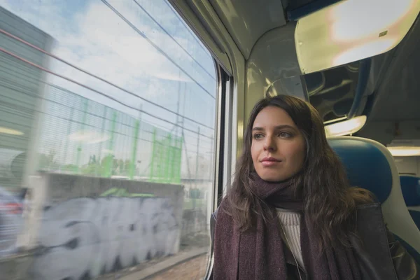 Beautiful young brunette travelling by train — Stock Photo, Image