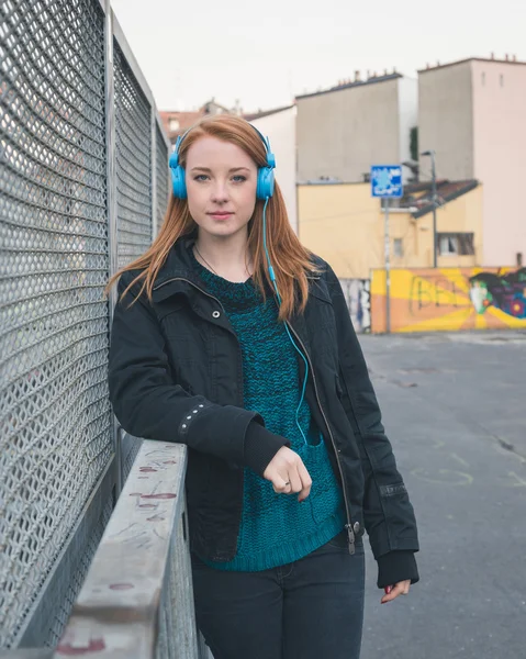 Menina bonita com fones de ouvido posando nas ruas da cidade — Fotografia de Stock