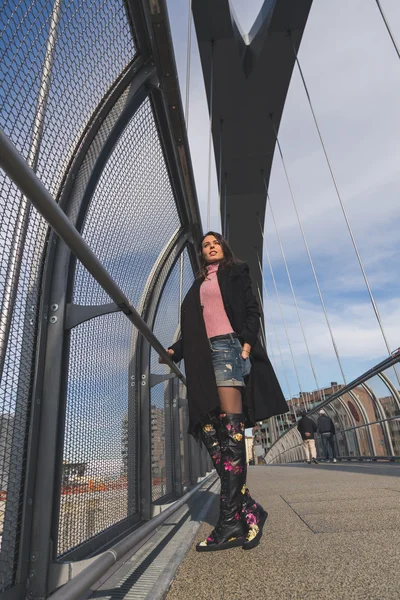 Beautiful young brunette posing on a bridge — Stock Photo, Image