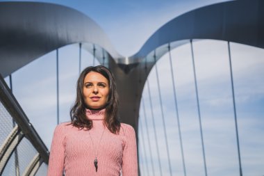 Güzel genç esmer bir köprüde poz