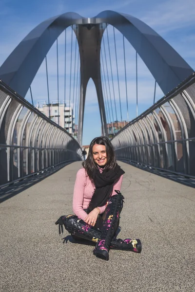 Beautiful young brunette posing on a bridge — Stock Photo, Image